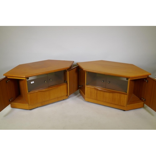 1047 - A pair of teak corner units with tinted glass doors over a single drawer, flanked by cupboards, 104 ... 