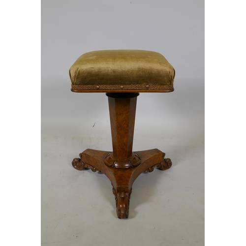 1050 - A 1920s figured walnut piano stool on a triform base, 52cm high