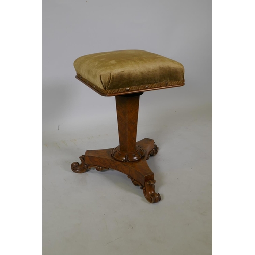 1050 - A 1920s figured walnut piano stool on a triform base, 52cm high