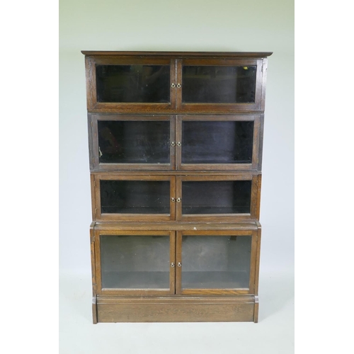 1051 - A 1930s oak two section bookcase, with six glazed doors over a stepped base of two more, 92 x 32 x 1... 