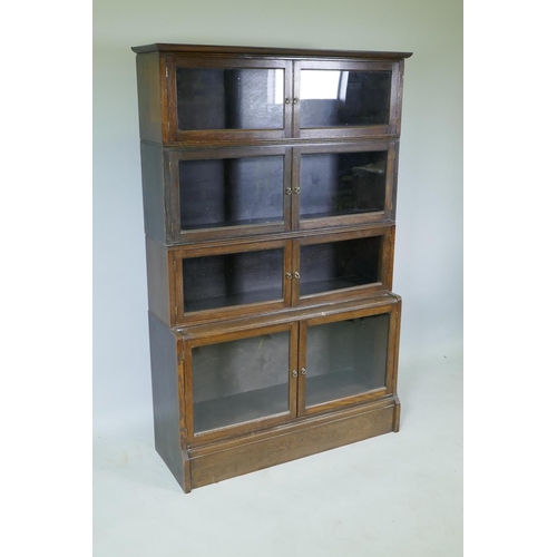 1051 - A 1930s oak two section bookcase, with six glazed doors over a stepped base of two more, 92 x 32 x 1... 