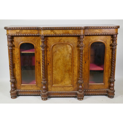 1058 - A Victorian figured walnut breakfront chiffonier with three arched panel doors (two glazed) flanked ... 