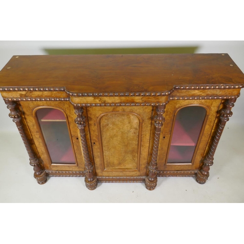 1058 - A Victorian figured walnut breakfront chiffonier with three arched panel doors (two glazed) flanked ... 