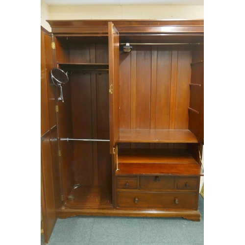 1060 - A Victorian mahogany wardrobe in two sections with single mirrored door, two cupboards over a fall f... 