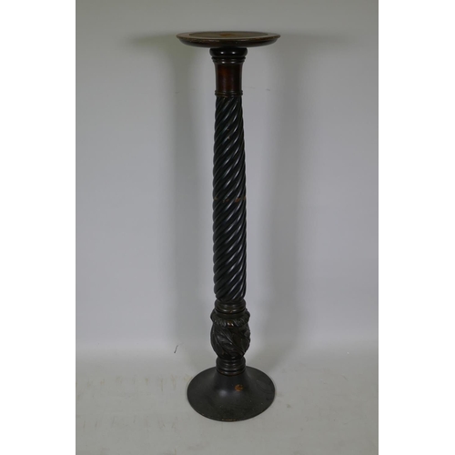 1061 - A mahogany torchere with leather inset top, raised on twisted column with carved base, 28cm diameter... 