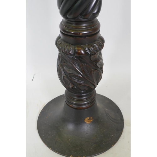 1061 - A mahogany torchere with leather inset top, raised on twisted column with carved base, 28cm diameter... 