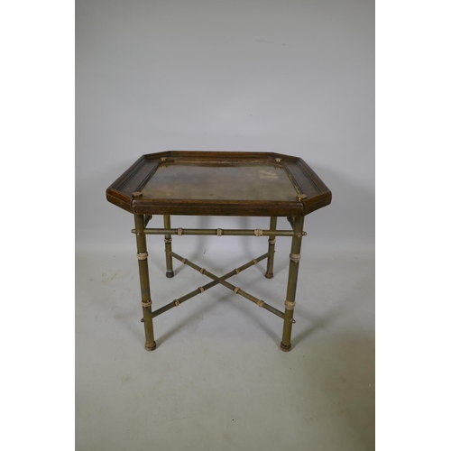 1064 - A coffee table with inset brass top and wood frame, raised on brass base with bamboo style turned mo... 