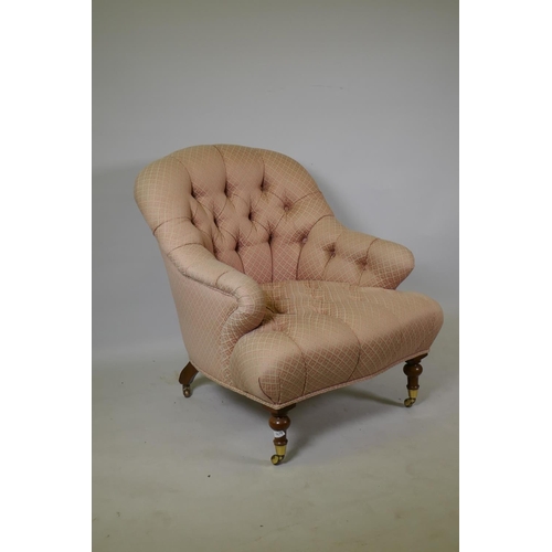 1070 - A Victorian style button back nursing chair, raised on turned mahogany supports with brass castors