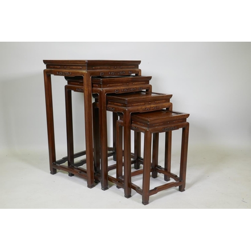 1084 - A Chinese rosewood nest of four occasional tables with finely carved friezes, raised on square suppo... 