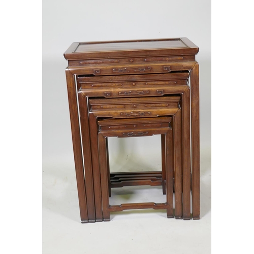 1084 - A Chinese rosewood nest of four occasional tables with finely carved friezes, raised on square suppo... 