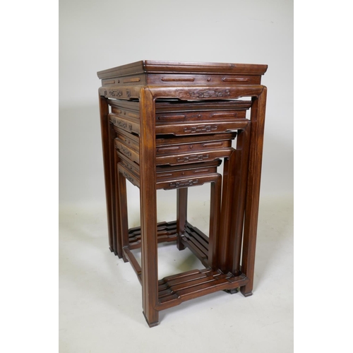 1084 - A Chinese rosewood nest of four occasional tables with finely carved friezes, raised on square suppo... 