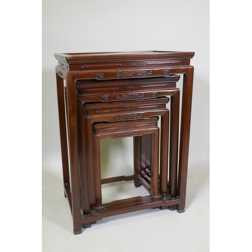 1084 - A Chinese rosewood nest of four occasional tables with finely carved friezes, raised on square suppo... 