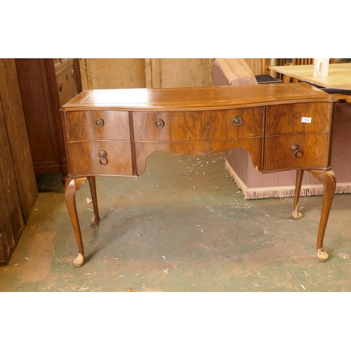 1114 - A 1930s serpentine front walnut five drawer kneehole desk with leather inset top, raised on cabriole... 