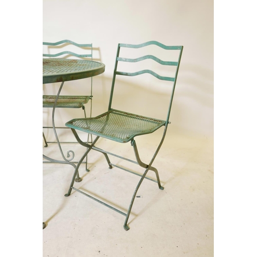 1115 - A vintage painted garden table and four matching folding chairs, 90cm diameter, 73cm high