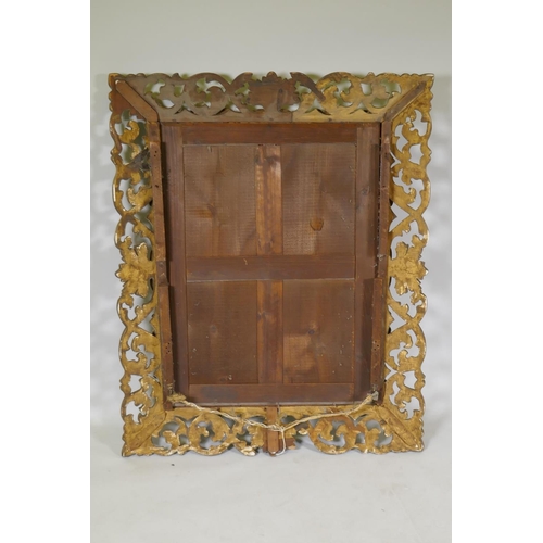 1125 - A carved and pierced giltwood Florentine style wall mirror with bevelled glass, late C19th/early C20... 