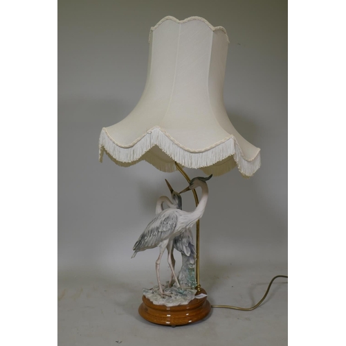 113 - A composition table lamp in the form of a pair of herons, with shade, 80cm high