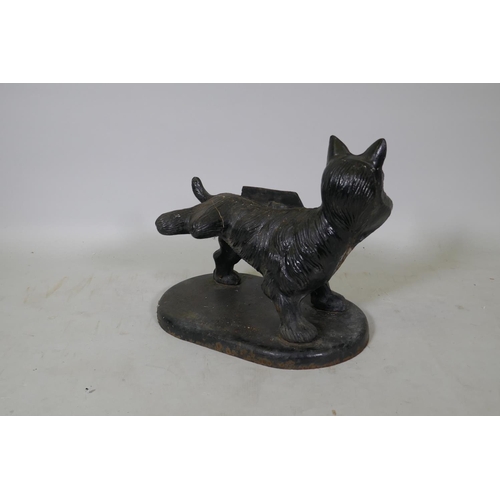 115 - A painted cast iron boot scraper in the form of a terrier cocking his back leg, 34cm high