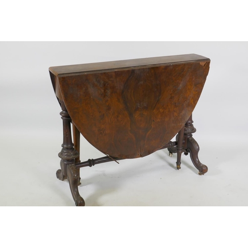 1170 - A Victorian figured walnut Sutherland table, raised on turned and carved end columns with cabriole s... 