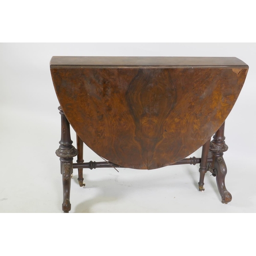 1170 - A Victorian figured walnut Sutherland table, raised on turned and carved end columns with cabriole s... 