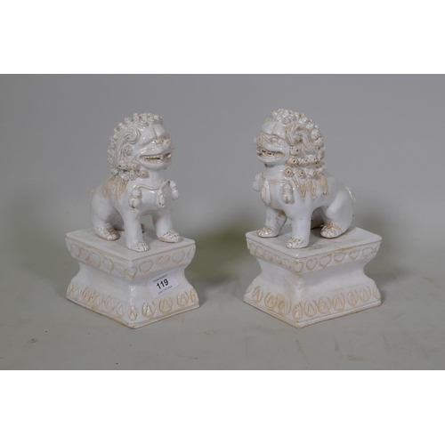 119 - A pair of white glazed terracotta figures of kylin, mounted on pedestals, 23cm high