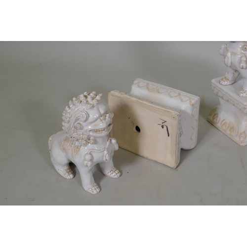 119 - A pair of white glazed terracotta figures of kylin, mounted on pedestals, 23cm high