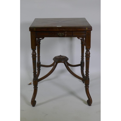 1196 - A Victorian mahogany envelope card table, raised on ring turned fluted supports with scroll ends, th... 