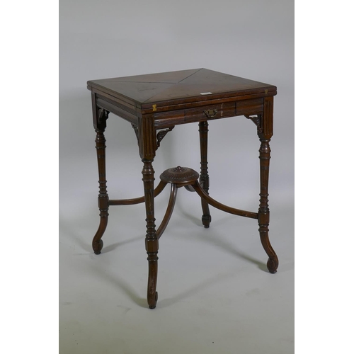 1196 - A Victorian mahogany envelope card table, raised on ring turned fluted supports with scroll ends, th... 