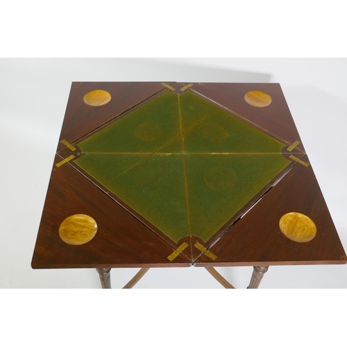 1196 - A Victorian mahogany envelope card table, raised on ring turned fluted supports with scroll ends, th... 