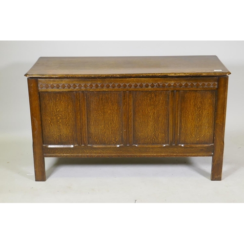 1199 - An oak coffer with four panel front, carved frieze and lift up top, mid C20th, 107 x 43 x 62cm