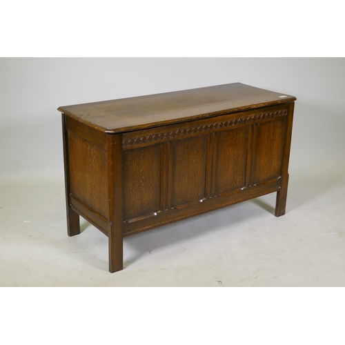 1199 - An oak coffer with four panel front, carved frieze and lift up top, mid C20th, 107 x 43 x 62cm