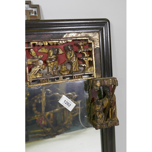 1202 - A Chinese lacquered wall mirror with carved, painted and parcel gilt frieze, early C20th, 90 x 62cm