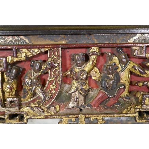 1202 - A Chinese lacquered wall mirror with carved, painted and parcel gilt frieze, early C20th, 90 x 62cm