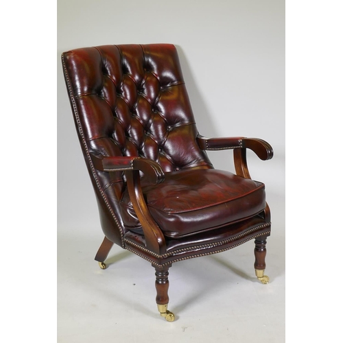 1205 - A Victorian style mahogany button back leather library chair with brass stud detail, raised on turne... 