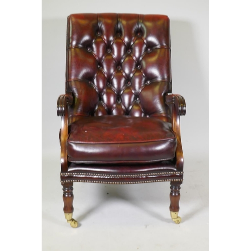 1205 - A Victorian style mahogany button back leather library chair with brass stud detail, raised on turne... 