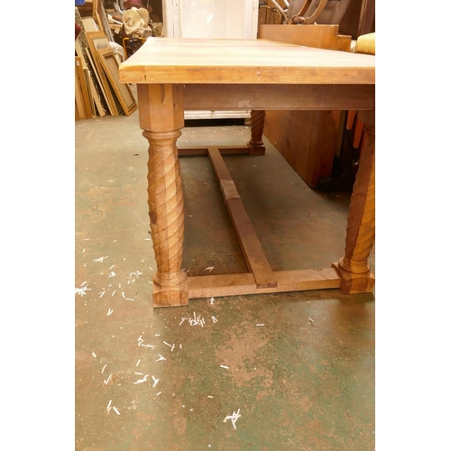 1211 - A bespoke yew wood refectory table with plank top, raised on twisted supports united by an H stretch... 