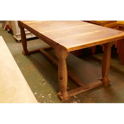 1211 - A bespoke yew wood refectory table with plank top, raised on twisted supports united by an H stretch... 