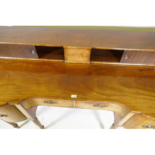 1213 - A George III mahogany sideboard with inverted front, the top with two tambour, front cupboards over ... 