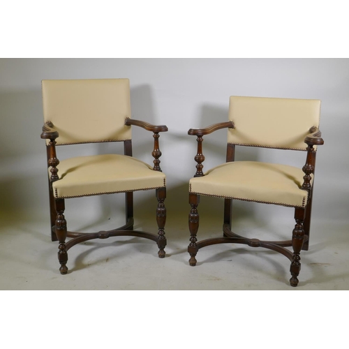 1216 - A pair of Continental oak show frame open arm chairs with leather upholstery and studded decoration,... 