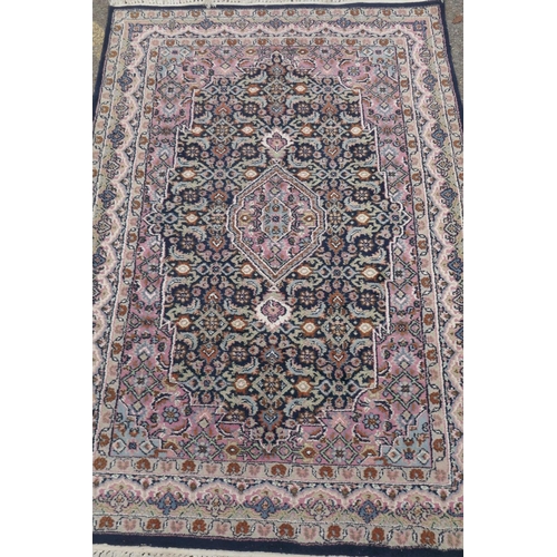 1220 - Oriental wool carpet with medallion design on a blue field with pink borders, 120 x 184cm