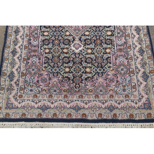 1220 - Oriental wool carpet with medallion design on a blue field with pink borders, 120 x 184cm