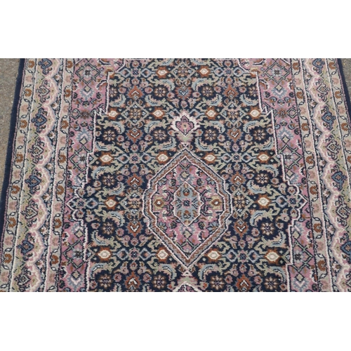 1220 - Oriental wool carpet with medallion design on a blue field with pink borders, 120 x 184cm