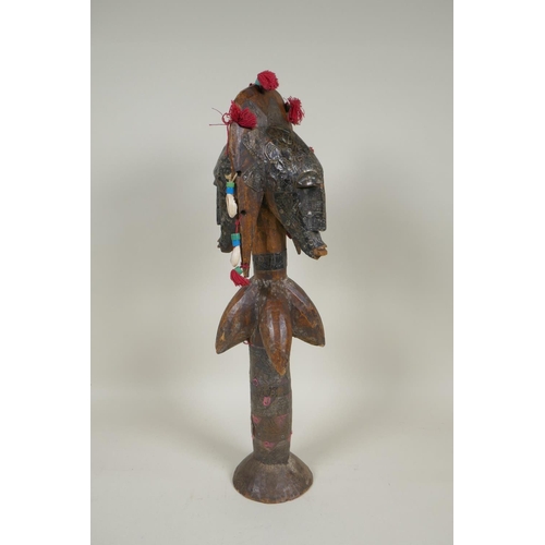 13 - An African wooden Bamana Janus puppet with decorative repousse metal mounts and shells, probably fro... 