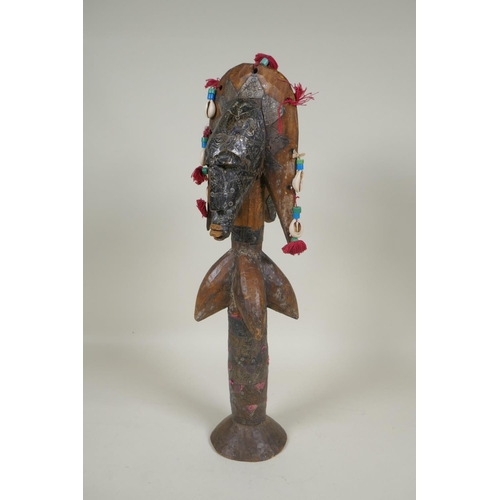 13 - An African wooden Bamana Janus puppet with decorative repousse metal mounts and shells, probably fro... 