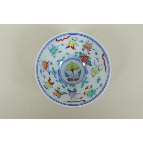 130 - A Chinese Doucai porcelain tea bowl of petal form, decorated with boys playing, 9cm diameter