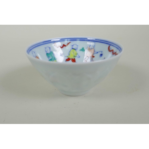 130 - A Chinese Doucai porcelain tea bowl of petal form, decorated with boys playing, 9cm diameter