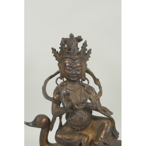 133 - A Tibetan gilt and coppered bronze figure of Guan Yin riding a duck, double vajra mark to base, 29cm... 