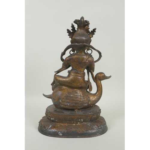 133 - A Tibetan gilt and coppered bronze figure of Guan Yin riding a duck, double vajra mark to base, 29cm... 