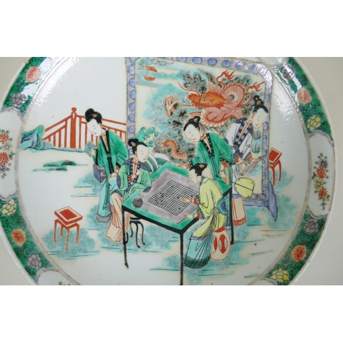 140 - A Chinese kangxi style famille verte porcelain charger decorated with women playing go, leaf mark to... 