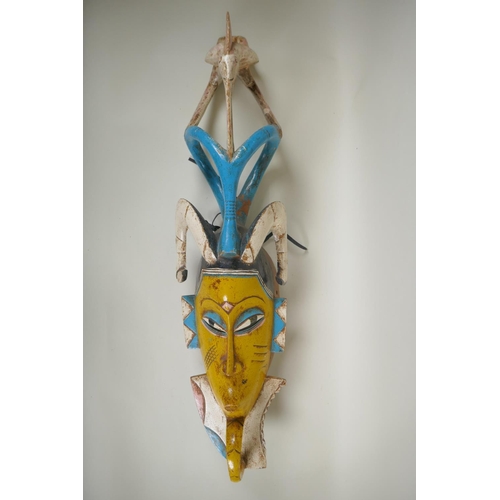 147 - An African carved and painted wood Guro mask, 80cm