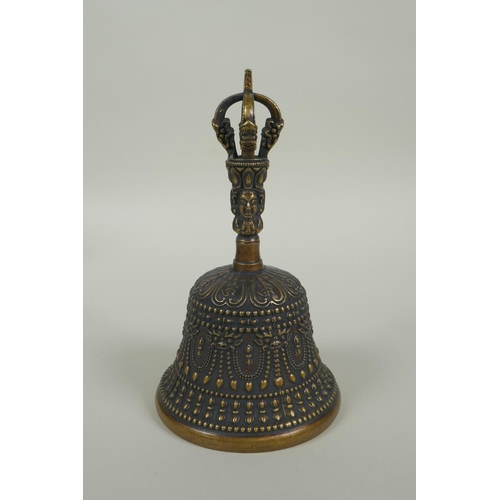 150 - A Tibetan ceremonial bronze bell with a vajra handle, 15cm high